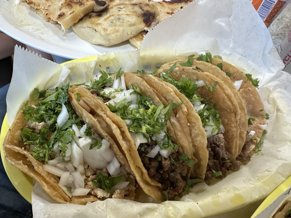 A basket of pupusas and street tacos served at Pupusería Casa María